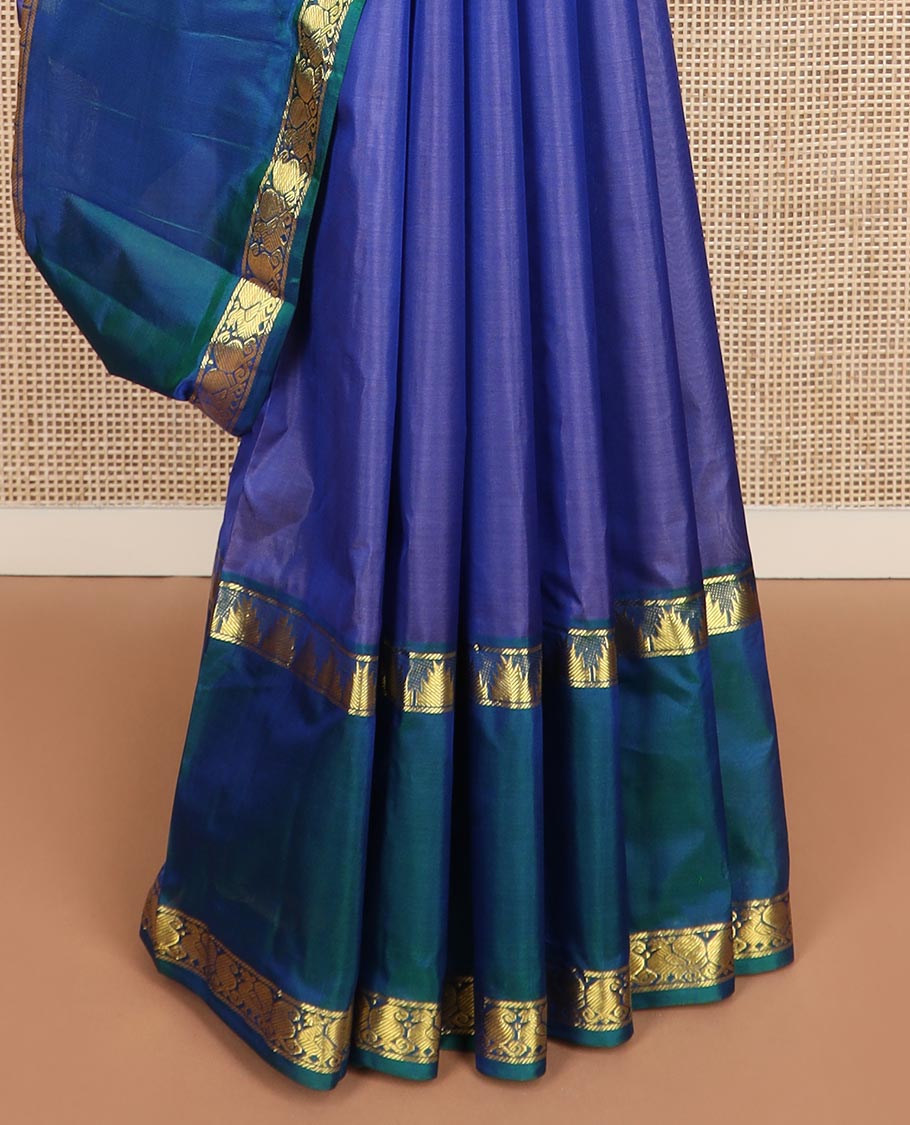 Blue plain Kanchipuram silk saree, contrast rettai pettu border of thazampoo rekku, manga, and mayil designs, and zari striped pallu
