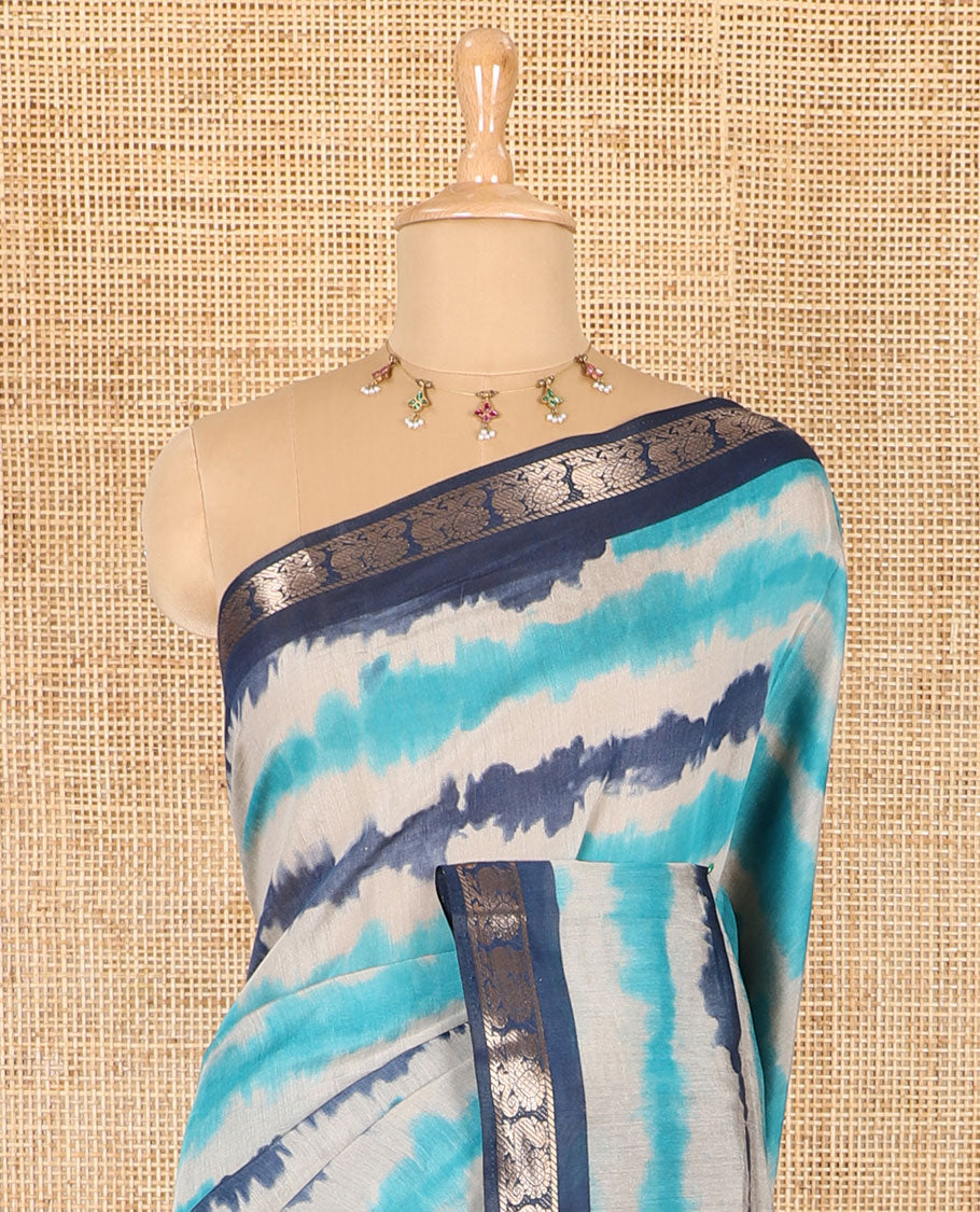 Blue shibori printed muslin cotton saree, contrast peacock zari border, village scenery printed pallu, and a contrast polka dotted zari border blouse