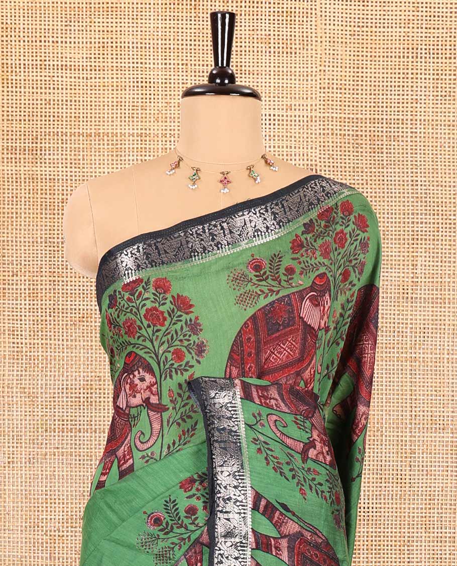 Green plain muslin cotton saree, contrast wedding-theme of floral and elephant motifs print, printed pallu, and a contrast buttas and zari bordered blouse