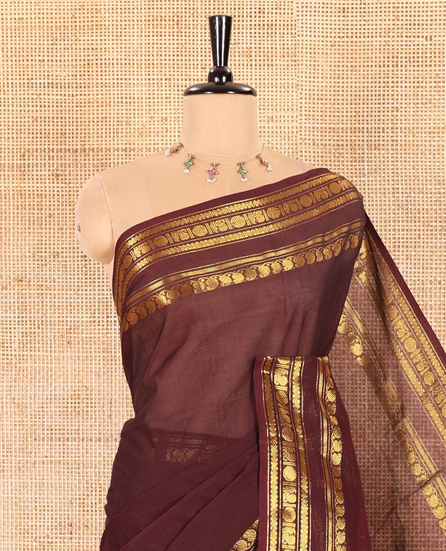 Coffee Brown Plain Chettinad Cotton Saree Graced with a Gleaming Zari Rettai Pettu Border Featuring Peacock, Rudraksham, and Neli Designs, Subtly Striped Pallu, and Paired with a Matching Blouse
