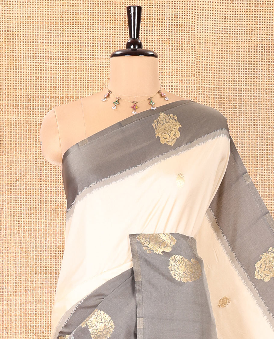 Cream Elite Soft Silk Saree, Accentuated with Zari Buttas All Over Its Body, Complemented by Contrast Border Steeped with Zari Buttas, Grand Jaal Design Pallu, and Paired with a Contrast Blouse