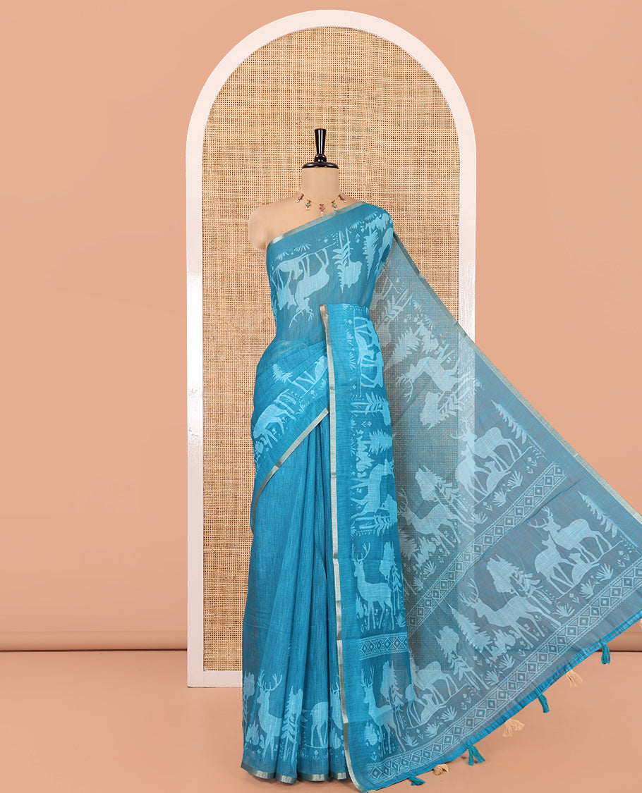 Rama Blue Christmas-Themed Linen Cotton Saree, Adorned with Christmas Tree Motifs Printed on Its Body, a Subtle Piping Border, Pallu of Christmas-Themed Print, and Paired with a Contrast Floral Printed Blouse