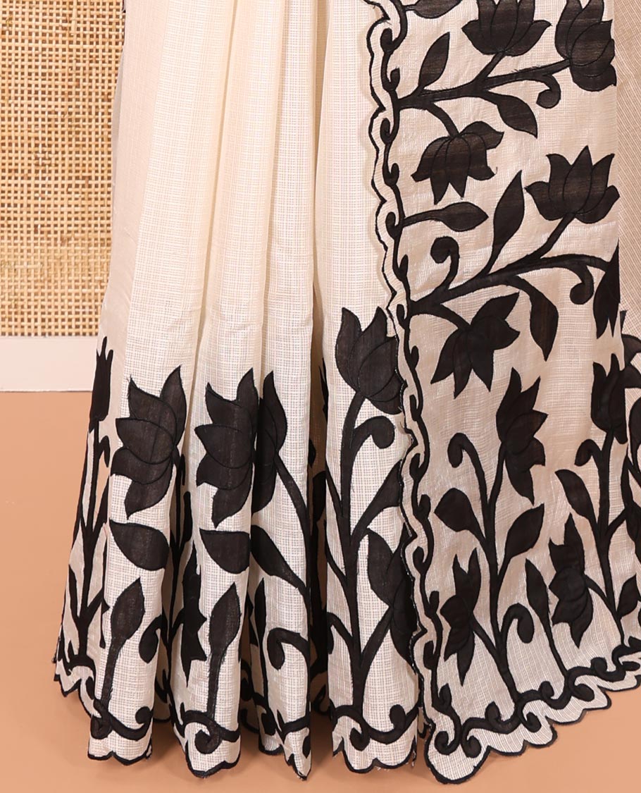 Cream and Black Plain Fancy Kota Silk Saree Sparsely Sparkled with Lotus Floral Applique Embroidered Scallop Border, Lotus Motifs Applique Embroidered Pallu, and a Contrast Plain Blouse