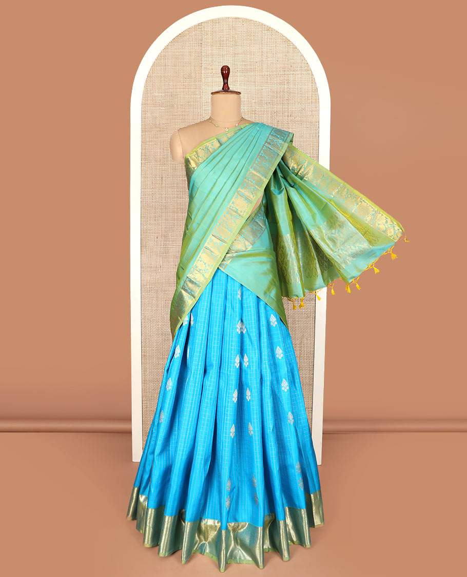 Blue Pure Silk Half-Saree Adorned with Zari Buttas Enclosed in Checks on the Skirt, Complemented by a Contrast Border Featuring Thilakam Mokku, Arumbu Manga, and Mayil Kann Designs, Paired with a Contrast Blouse, and a Jaal Design Dhavani
