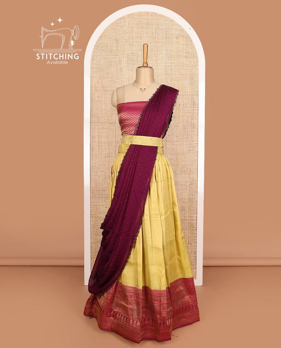 Yellow art silk half-saree, brocade with contrast traditional border skirt, contrast maroon brocade blouse, scallop stone work dhavani, and detachable belt