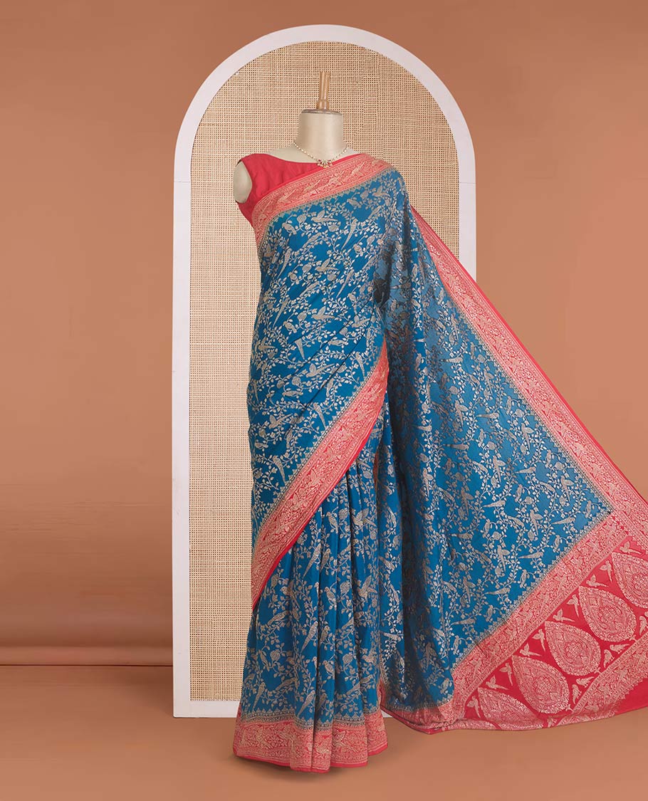 Blue floral and bird jaal jacquard banaras crepe saree, contrast floral and bird jaal zari border, and pallu of Mughal style motifs
