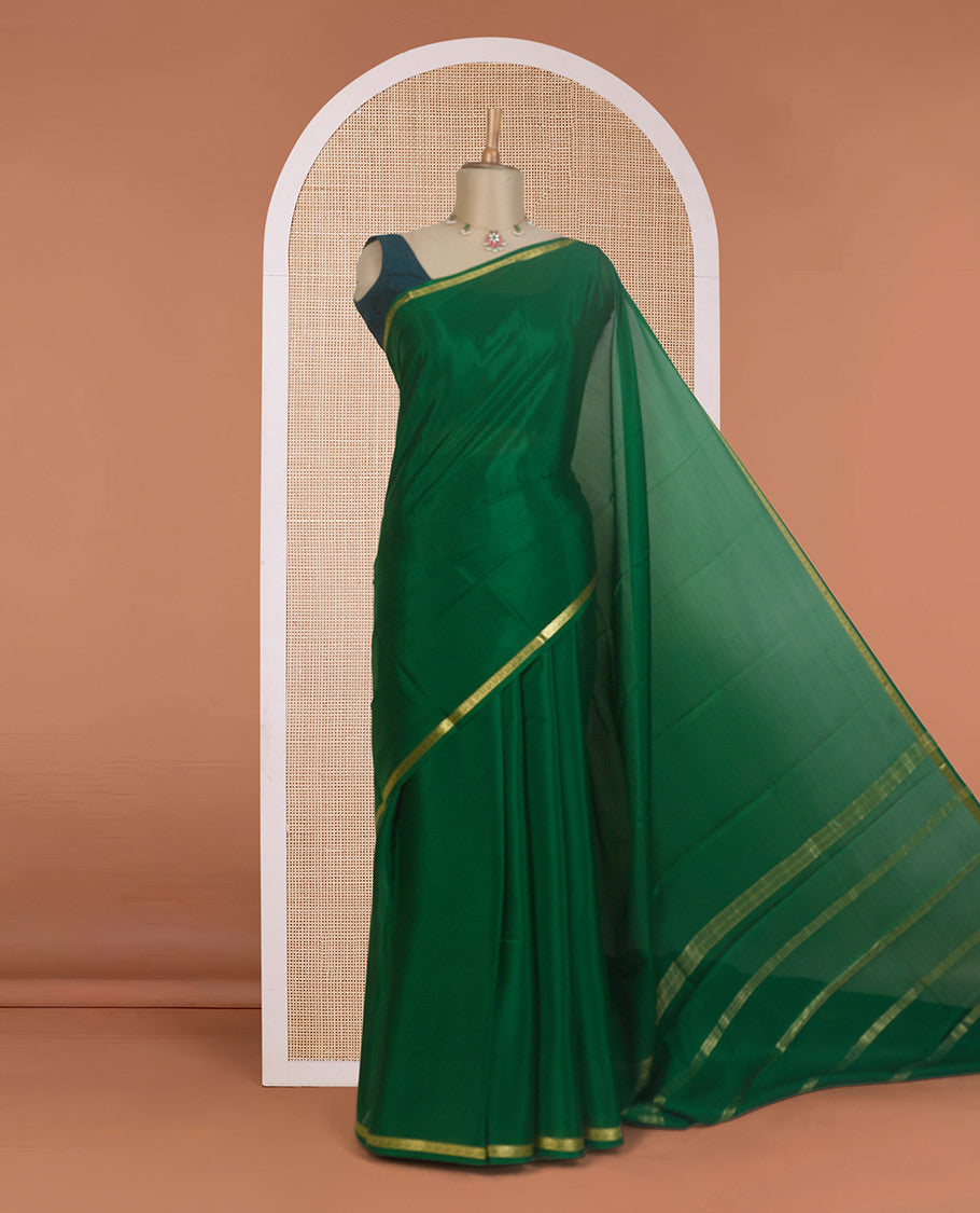 Dark green plain Mysore silk saree, zari border of floral creeper designs, and zari striped pallu