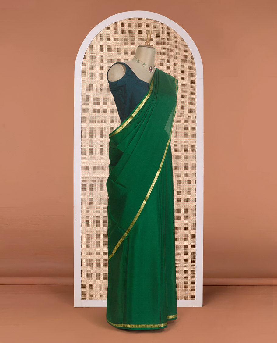 Dark green plain Mysore silk saree, zari border of floral creeper designs, and zari striped pallu
