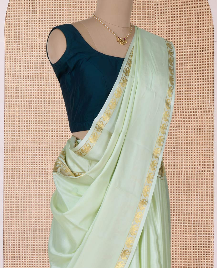 Pale green plain Mysore silk saree, rettai pettu border of elephant motifs, and pallu of stripes in zari