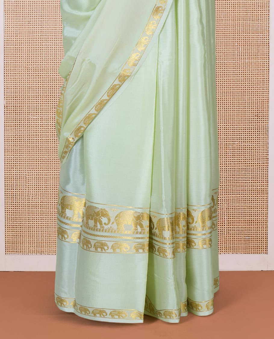 Pale green plain Mysore silk saree, rettai pettu border of elephant motifs, and pallu of stripes in zari