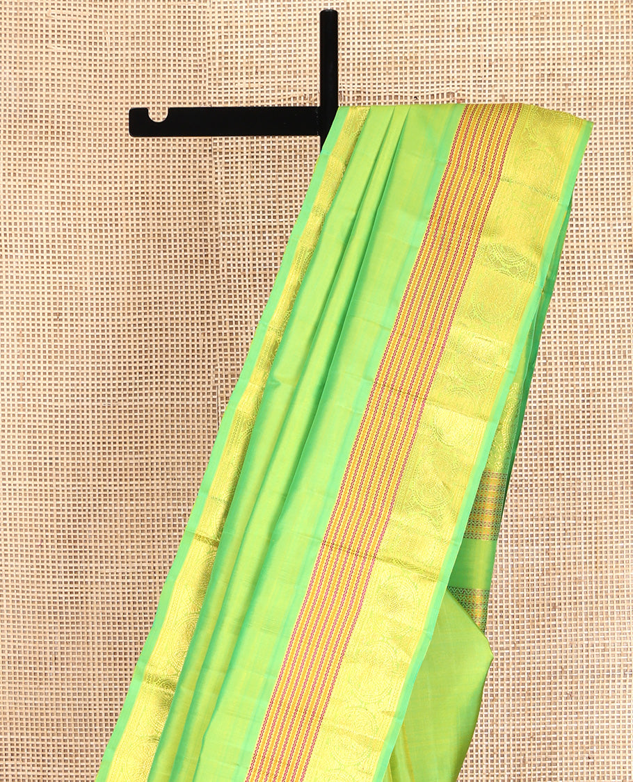 Green Plain Kanchipuram Silk Saree, Highlighted by Self-Border of Neli, and Round Iruthalai Pakshi Designs, Pallu of Same Design, and Paired with a Matching Blouse