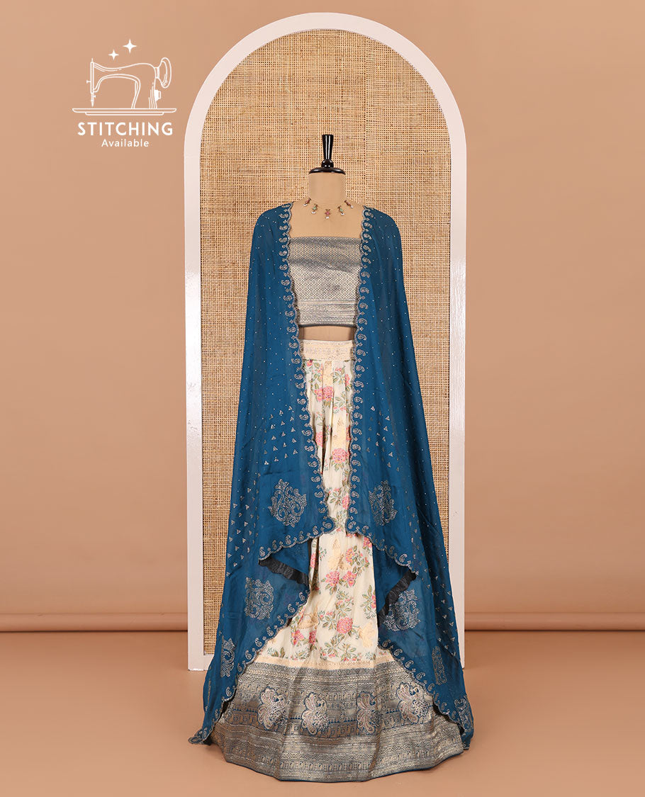 Cream and peacock blue half-saree, floral and bird printed nylon viscose crepe top, contrast traditional zari and stone work border, jacquard banaras blouse, and scallop stone work dhavani