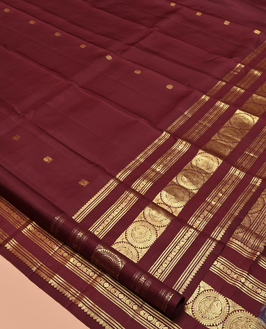 Maroon Kanchipuram Silk Saree, Crafted with Mayil and Chakram Buttas All Over Its Body, Highlighted by a Zari Border of Thilakam Mokku, Kathir, Kamalam, Manga, and Round Mayil Designs, Grand Jaal Pallu, and Paired with a Matching Blouse
