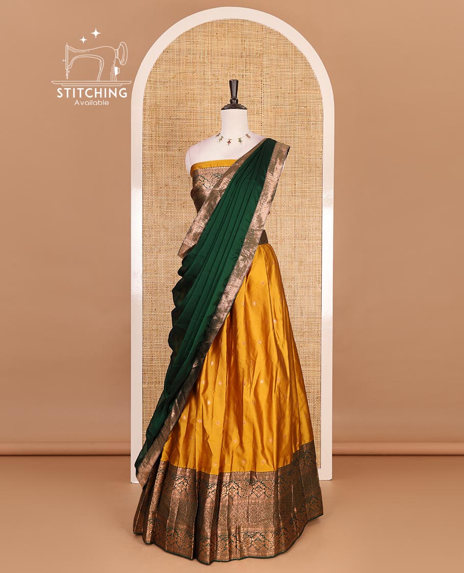 Mustard taffeta silk half saree, zari buttas with contrast green traditional zari border, matching zari blouse, and contrast plain zari border dhavani