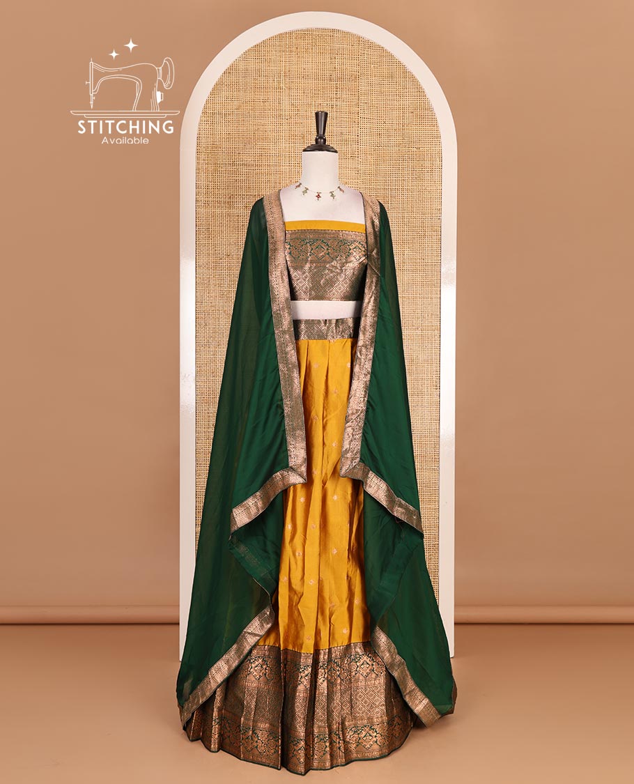 Mustard taffeta silk half saree, zari buttas with contrast green traditional zari border, matching zari blouse, and contrast plain zari border dhavani