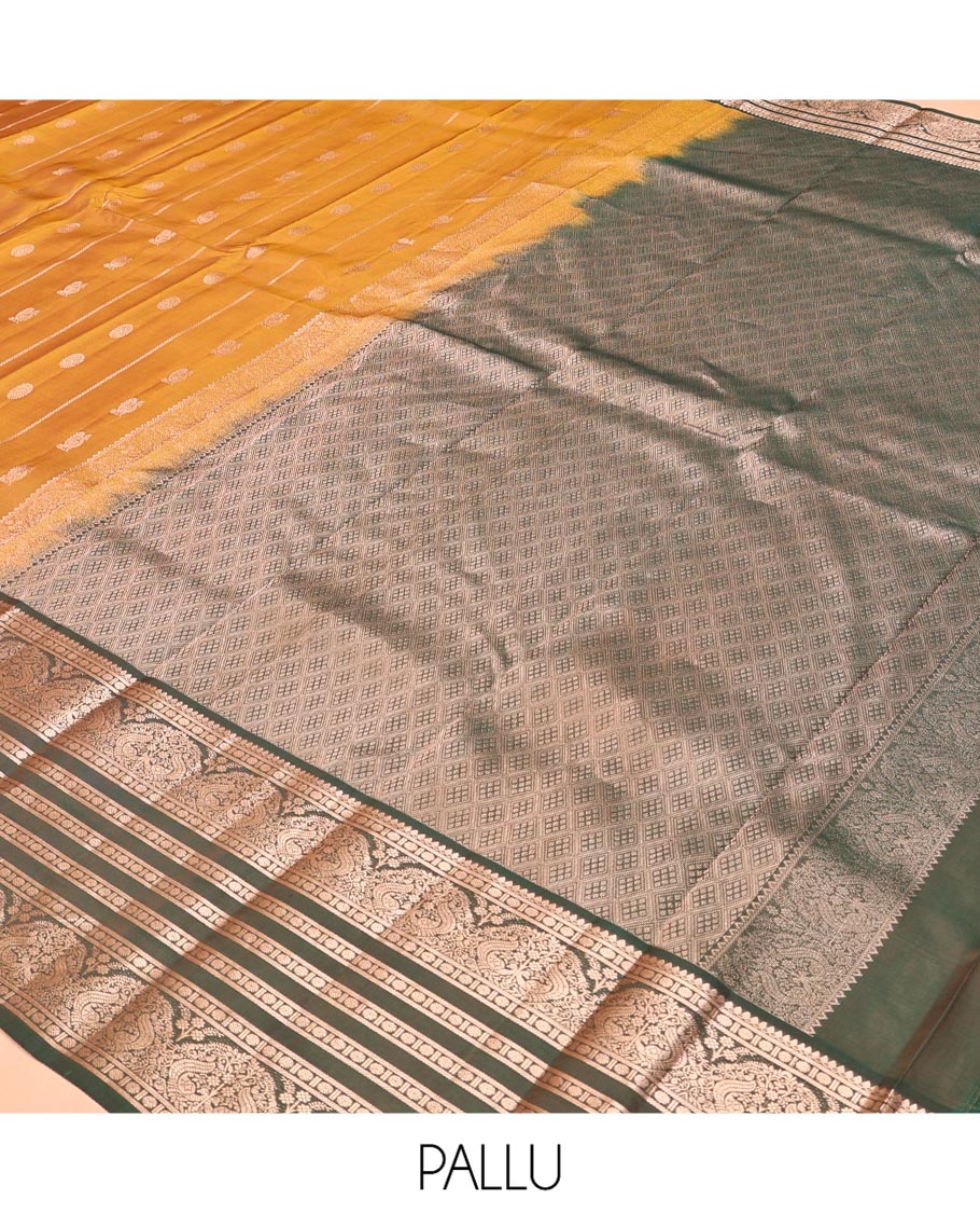 Mustard Vasundhara Lite Silk Mix Saree, Richly Detailed with Zari Buttas and Stripes All Over Its Body Complemented by Contrast Border of Thilakam Mokku, Rudraksham, and Mayil Designs, Grand Jaal Pallu, and Paired with a Contrast Blouse