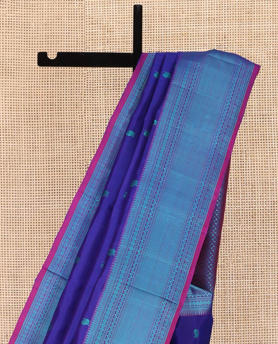Blue Kanchipuram Silk Saree, Detailed with Mayil-Chakram Buttas All Over Its Body, Complemented by a Contrast Border of Thilakam, Banaras, Muthu, Rudraksham, Neli, and Vanki Designs, Pallu Steeped with Kamalam Designs, and Paired with a Contrast Blouse
