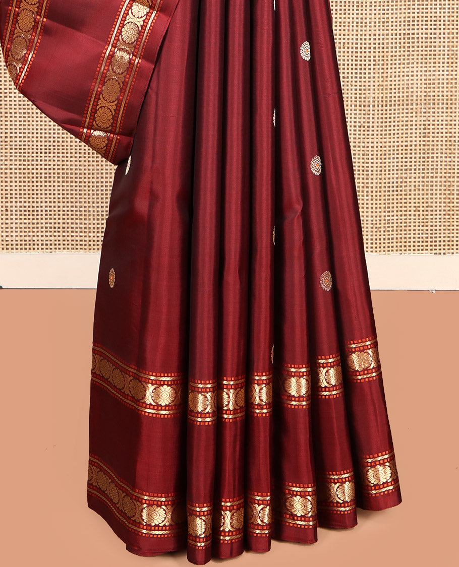 Maroon Kanchipuram Silk Saree, Adorned with Chakram Buttas, Highlighted by a Rettai Pettu Zari Border of Muthu, Banaras, and Cross Kamalam Designs, Mayil-Chakram Pallu and a Matching Blouse