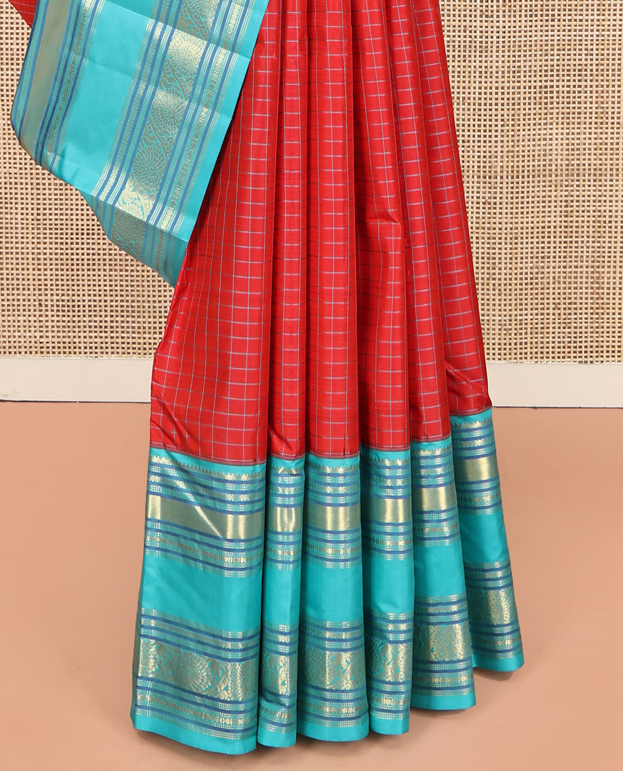Tomato Red and Blue Vasundhara Silk Saree, Subtly Sparkled With Pattu Nool Kattam On Its Body, Complemented by Contrast Rettai Pettu Border of Salngai, Muthu, Neli, Rudraksham, and Dhavana Kodi Designs, Grand Pallu and Paired with a Contrast Blouse