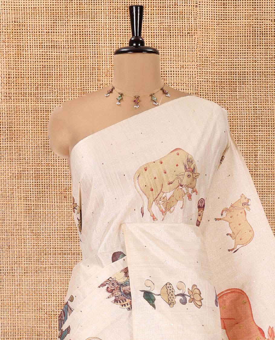 Borderless Cream Semi-Tussar Saree, Artfully Printed with Ancient Human Figurines, Floral, and Pichwai Cow on Its Body, Highlighted by Kalamkari-Style Human Motifs Printed Pallu, and Paired with a Matching Pichwai Cow Printed Blouse