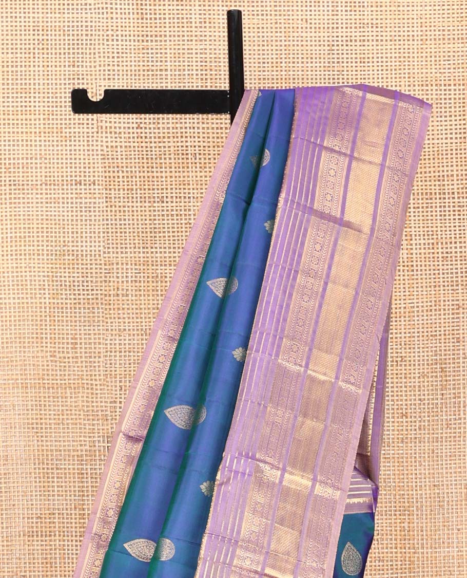 Blue Vasundhara Silk Saree, Adorned with Thilakam and Floral Buttas on Its Body, Complemented by a Contrast Border of Rekku, Muthu, Kathir, Kamalam, Diamond, and Mayil Kann Designs, Pallu Steeped with Intricate Designs, and Paired with a Contrast Blouse