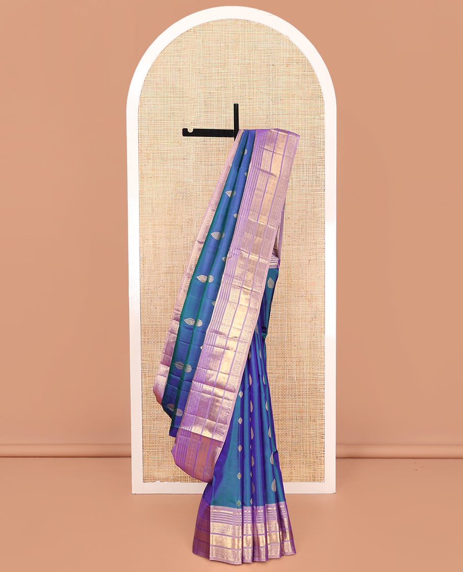 Blue Vasundhara Silk Saree, Adorned with Thilakam and Floral Buttas on Its Body, Complemented by a Contrast Border of Rekku, Muthu, Kathir, Kamalam, Diamond, and Mayil Kann Designs, Pallu Steeped with Intricate Designs, and Paired with a Contrast Blouse