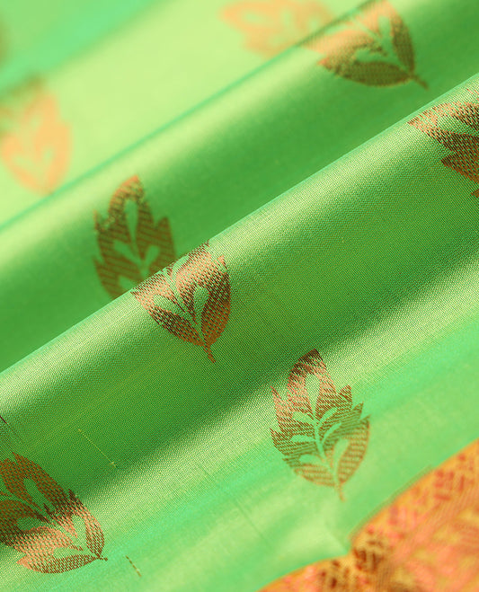 Green navarathna pavadai with leaf-shape buttas, contrast zari border & blouse of traditional zari designs