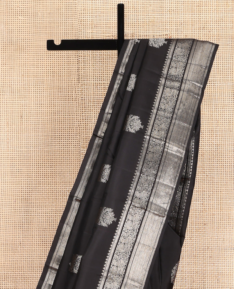 Black Kanchipuram Silk Saree, Dazzled with Zari Buttas All Over Its Body, Highlighted by Zari Border of Rekku, Kathir, Vanki, and Mayil Designs, Pallu of Jaal Design, and Paired with a Matching Blouse
