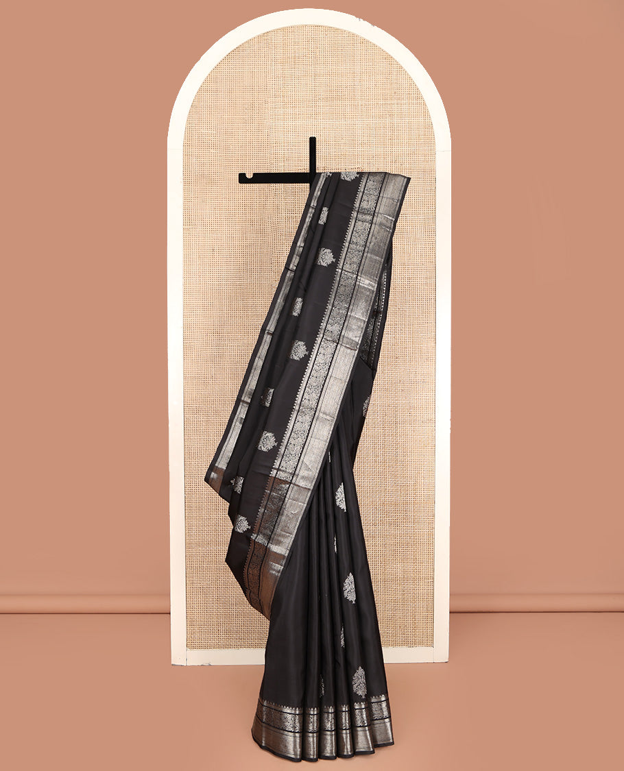 Black Kanchipuram Silk Saree, Dazzled with Zari Buttas All Over Its Body, Highlighted by Zari Border of Rekku, Kathir, Vanki, and Mayil Designs, Pallu of Jaal Design, and Paired with a Matching Blouse