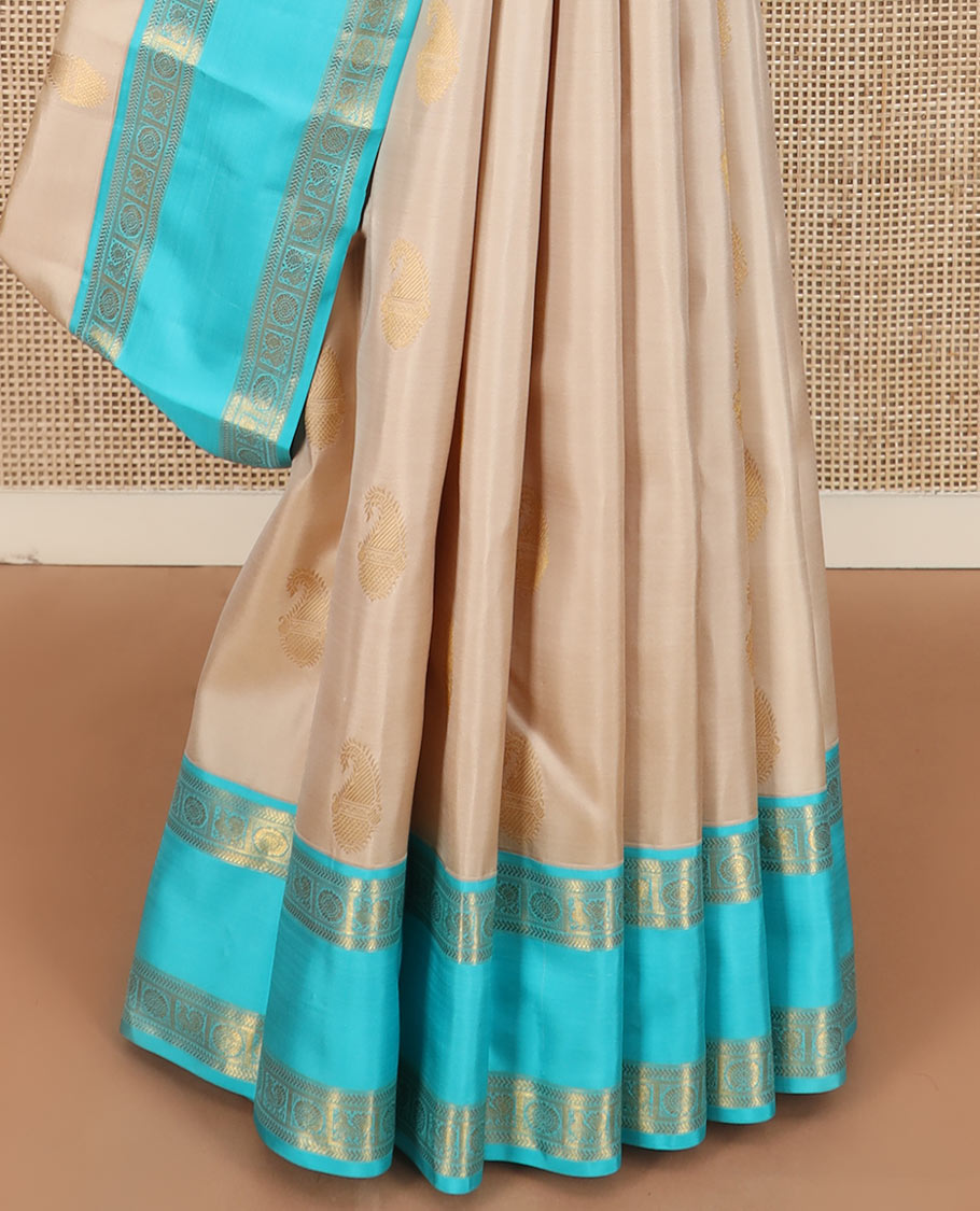 Cream manga buttas Kanchipuram silk saree, contrast rettai pettu border of kathir and annam chakram motifs, and butta enclosed checked pallu