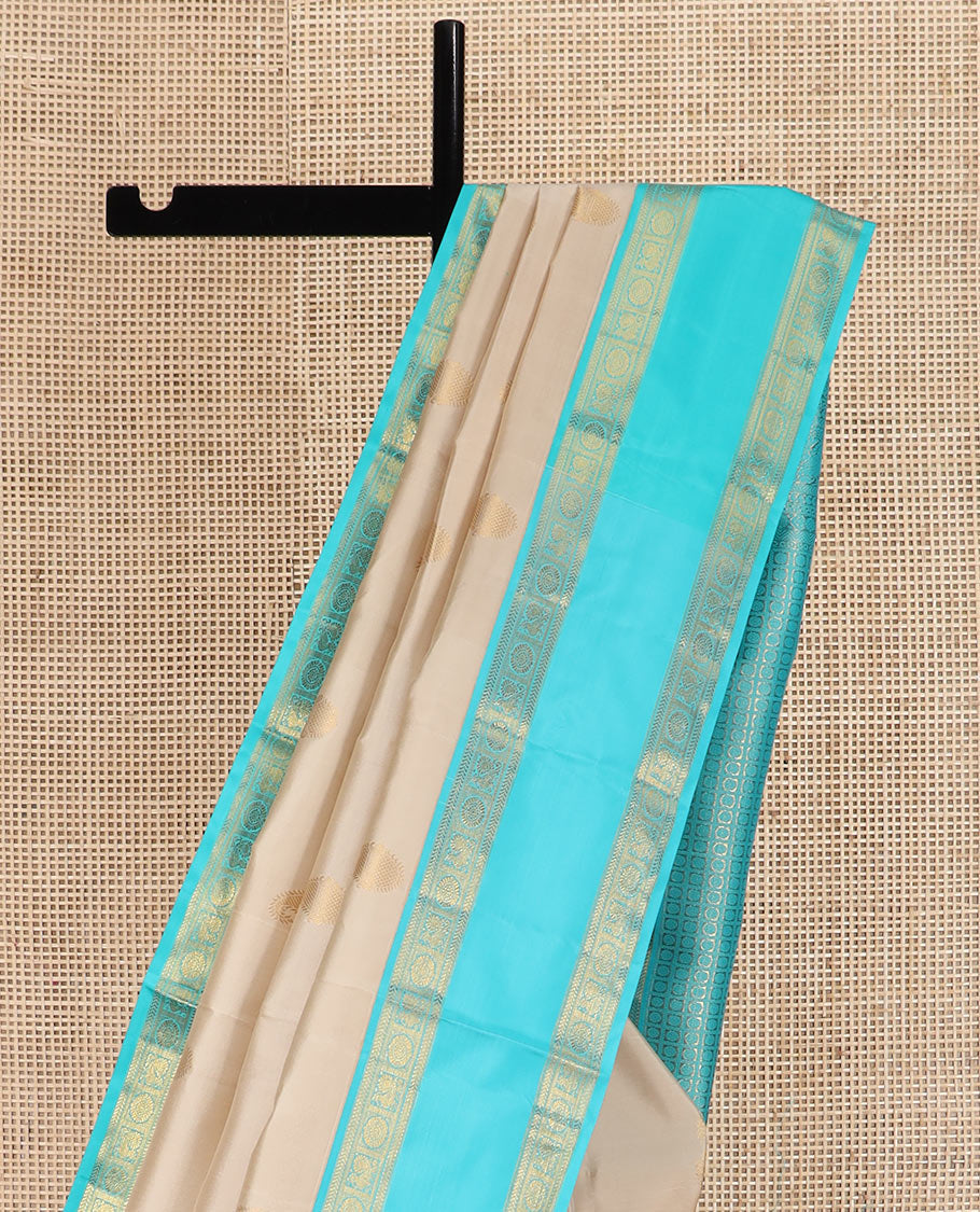 Cream manga buttas Kanchipuram silk saree, contrast rettai pettu border of kathir and annam chakram motifs, and butta enclosed checked pallu