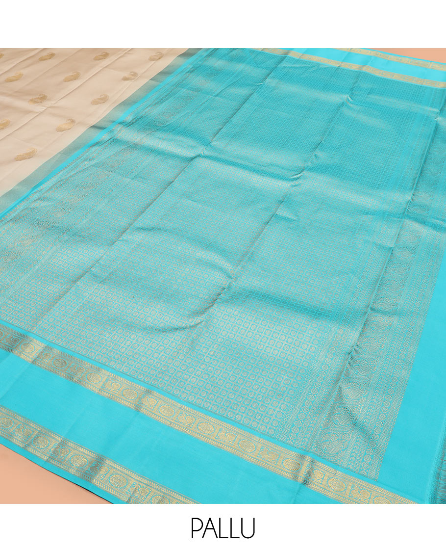 Cream manga buttas Kanchipuram silk saree, contrast rettai pettu border of kathir and annam chakram motifs, and butta enclosed checked pallu