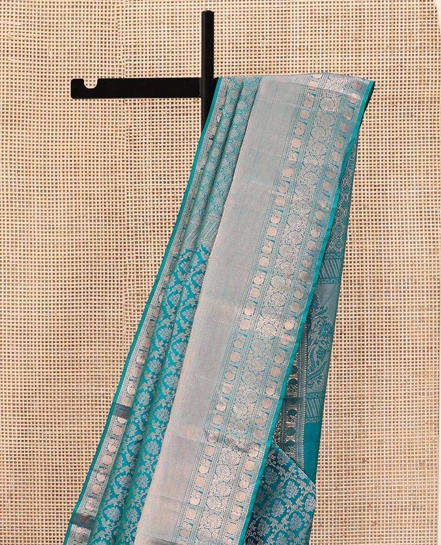 Rama Blue Kanchipuram Wedding Silk Saree, Mesmerized with Jaal Jacquard on Its Body, Highlighted by a Zari Border of Thilakam Mokku, Poun, Mayil, and Kodi Visiry Designs, Grand Pallu Steeped with Chakram Designs, and Paired with a Matching Blouse
