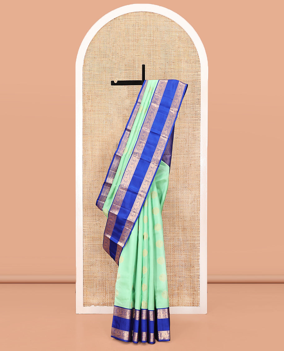 Pastel Sea Green Vasundhara Silk Saree, Ornamented with Zari Buttas All Over Its Body, Complemented by a Contrast Rettai Pettu Border of Rekku, Ara Maadam, and Mayil Designs, Grand Pallu, and Paired with a Contrast Blouse