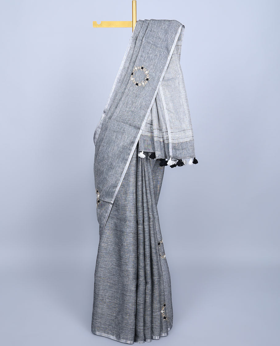 Borderless grey thread embroidered linen saree features floral motifs, pallu of sequin stripes & tassels