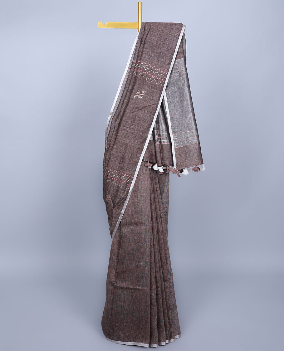 Borderless brown embroidered linen saree features geometric designs, self-pallu of stripes with tassels