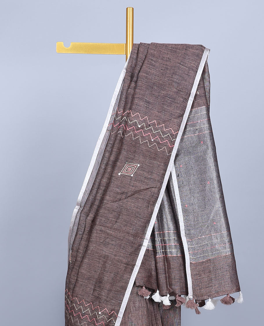 Borderless brown embroidered linen saree features geometric designs, self-pallu of stripes with tassels