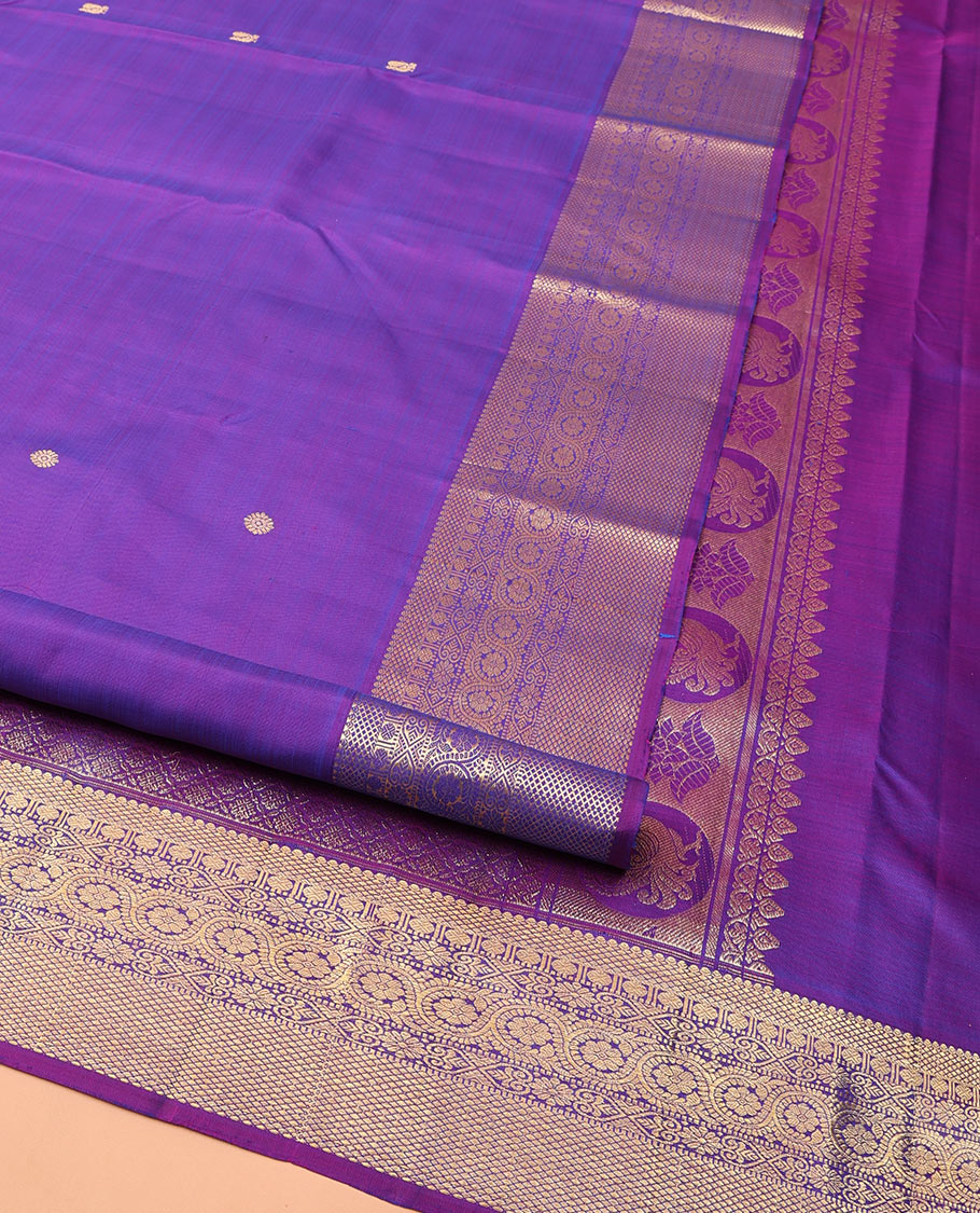 Violet Kanchipuram Silk Saree, Ornamented with Zari Buttas All Over Its Body, Highlighted by Zari Border of Thilakam, Mayil Kann, Poun, Jada Nagam, Dhavana Kodi, and Mayil Kann Designs, Pallu of Jaal Designs, and Paired with a Matching Blouse
