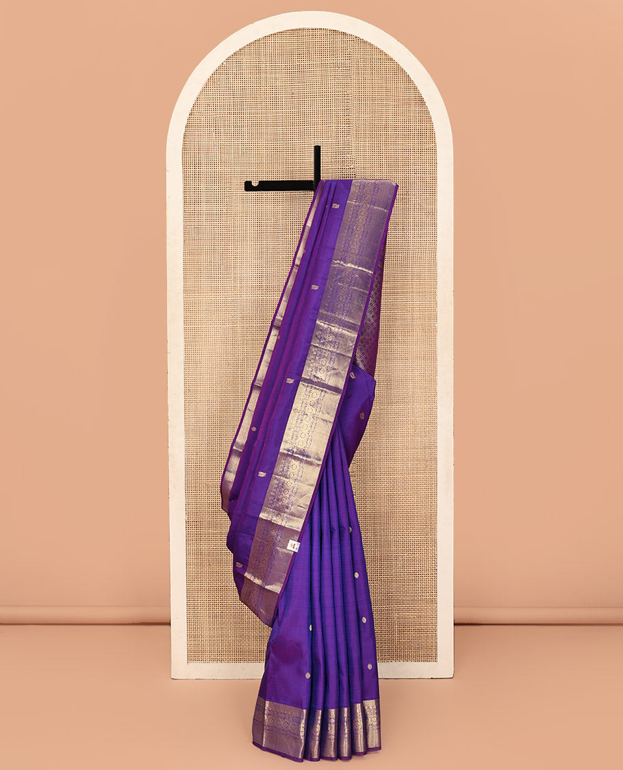 Violet Kanchipuram Silk Saree, Ornamented with Zari Buttas All Over Its Body, Highlighted by Zari Border of Thilakam, Mayil Kann, Poun, Jada Nagam, Dhavana Kodi, and Mayil Kann Designs, Pallu of Jaal Designs, and Paired with a Matching Blouse