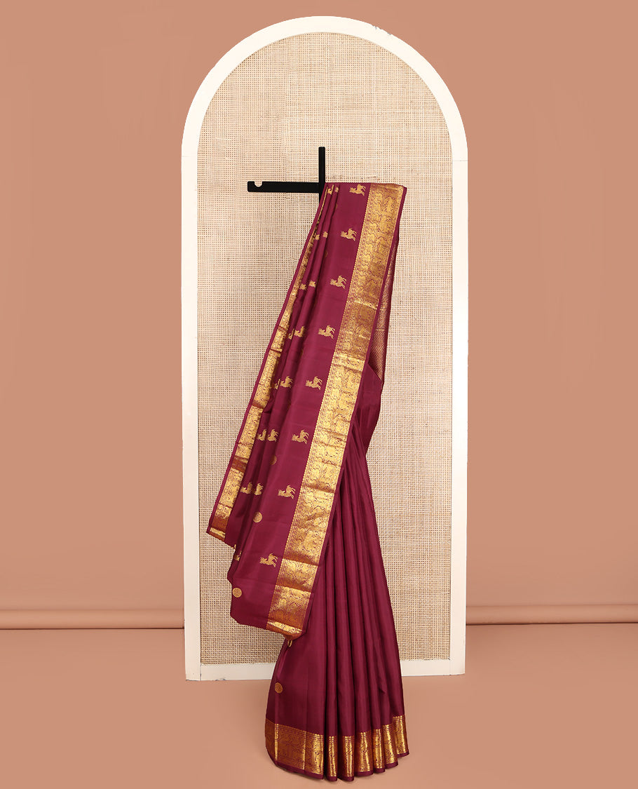 Red Kanchipuram Silk Saree, Lightly Embellished with Kuthirai and Chakram Buttas All Over Its Body, Highlighted by Zari Border of Salngai, Poun, Mayil, Yaali, and Yaanai Designs, Pallu of Ara Maadam Design, and Paired with a Matching Blouse