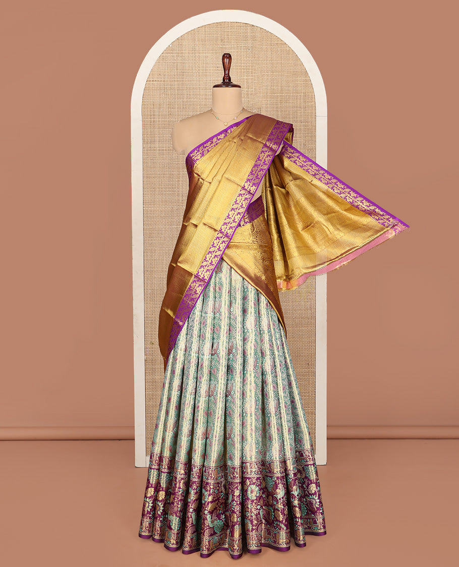Green Pure Silk Half-Saree, Artfully Detailed with Floral Jacquard All Over Its Skirt, Complemented by a Contrast Border of Yaanai, Mayil, and Kodi Visiry Designs, Paired with a Contrast Blouse, and Comes with an Intricately Designed Dhavani