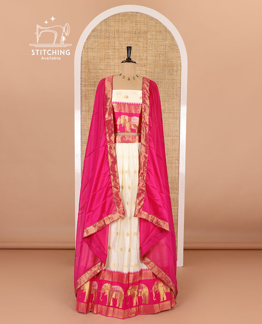 Cream-pink half-saree, zari buttas with contrast traditional zari elephant motifs bordered skirt, matching blouse and a contrast zari border dhavani
