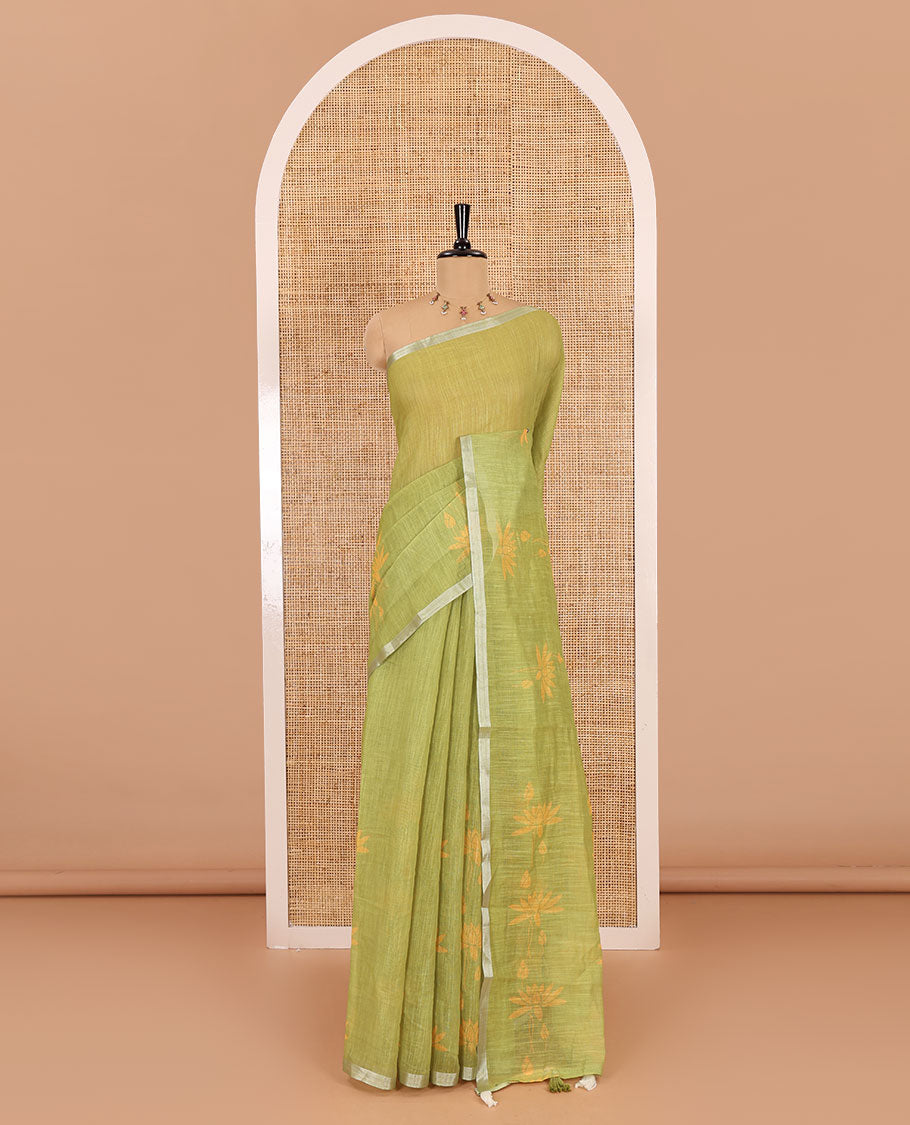 Green Pichwai lotus printed linen cotton saree, piping zari border, colorful tasselled lotus printed pallu, and a contrast lotus printed blouse