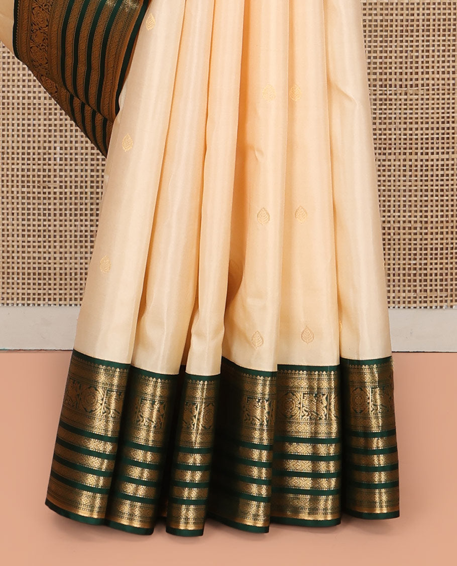 Cream Vasundhara Silk Saree, Enthralled with Zari Buttas All Over Its Body, Complemented by a Contrast Border of Muthu, Diamond, Kuthirai, Chakram, and Diamond Designs, Grand Pallu, and Paired with a Contrast Blouse