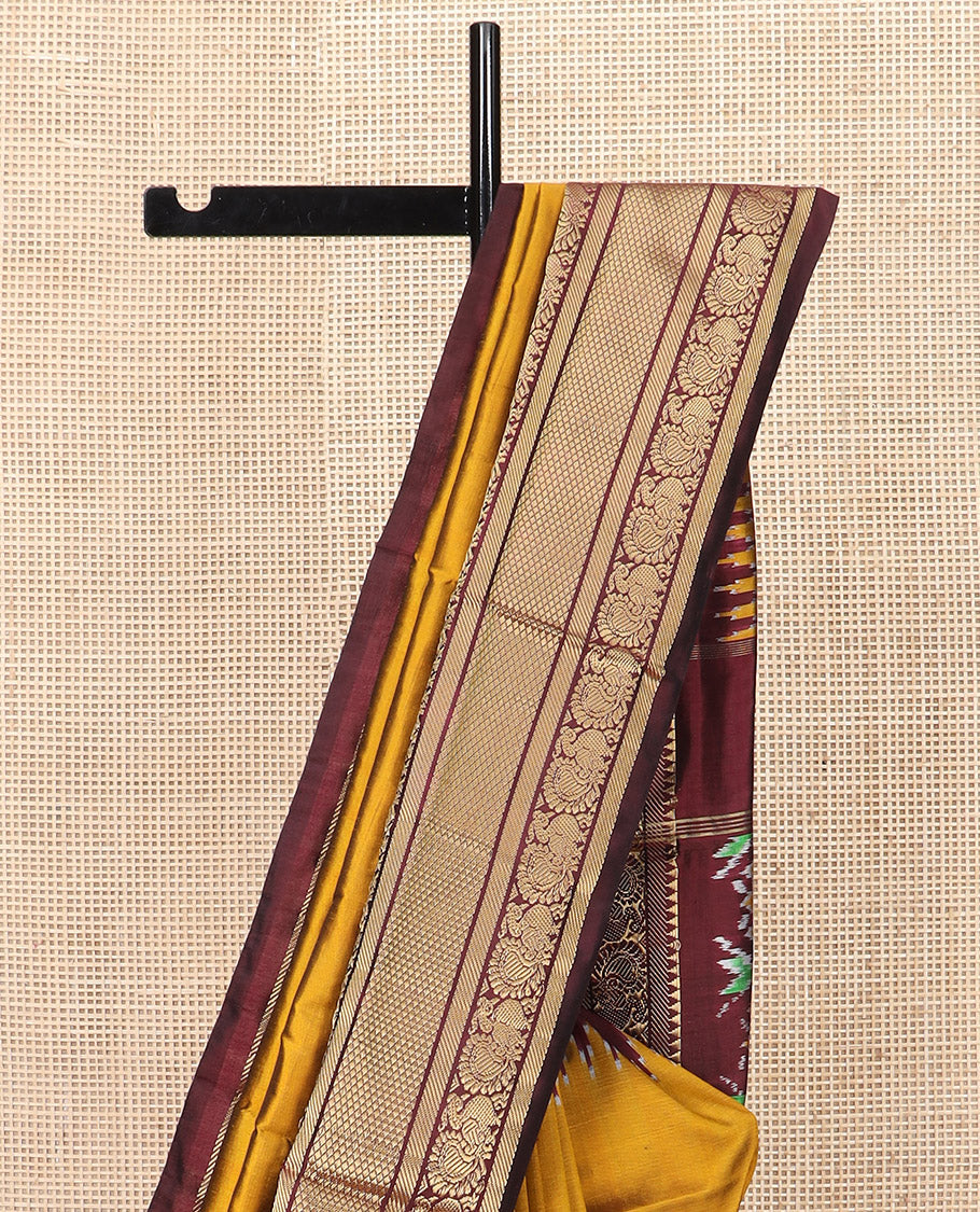 Mustard Plain Ikkat Silk Saree, Complemented by a Contrast Temple Traditional Zari Motif Woven Border, Pallu Adorned with Vibrant Jaal Design, and Paired with a Multi-Coloured Blouse