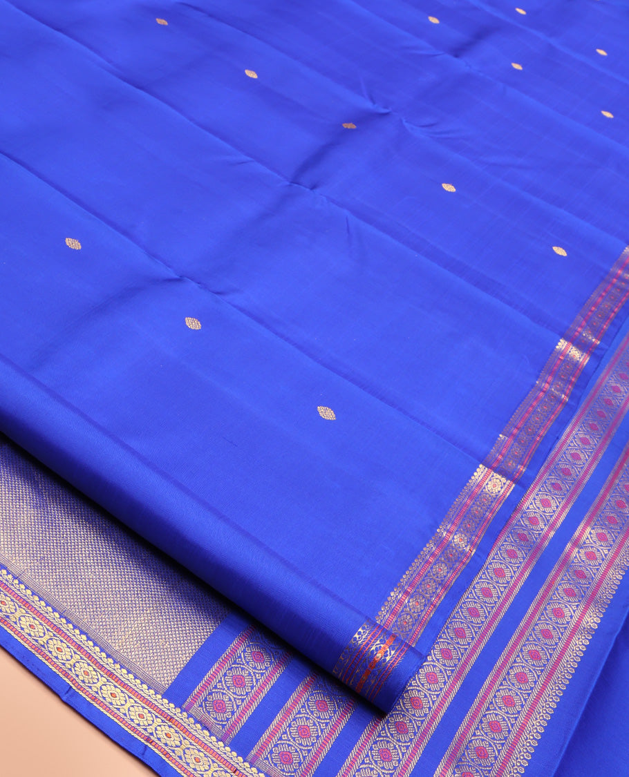 Royal Blue Kanchipuram Silk Saree, Elevated with Zari Buttas All Over Its Body, Highlighted by Zari Border of Salngai, Muthu, and Chakram Designs, Pallu of Mayil Kann Design, and Paired with a Matching Blouse