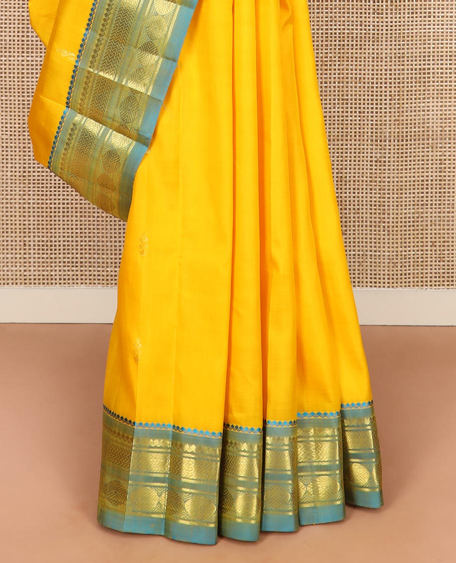 Yellow Kanchipuram Silk Saree Subtly Sparkled with Zari Buttas All Over Its Body, Complemented by a Contrast One-Sided Border of Thilakam Mokku, Banaras, Vanki, and Rudraksham Designs, Pallu of Zari Motifs, and Comes Without a Blouse