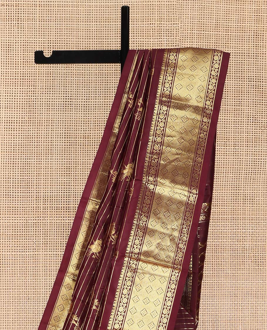 Maroon Kanchipuram Silk Saree, Gleamed Up with Zari Stripes and Bird Buttas on Its Body, Highlighted by a One-Sided Border of Kodi Visiry, and Jaal Designs, Pallu of Geometric Designs, and Comes Without a Blouse