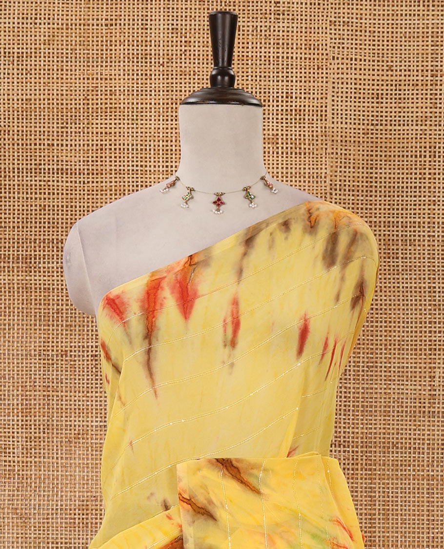 Borderless yellow shibori-style printed & sequins work marble chiffon saree, self-pallu with tassels & contrast embroidered blouse