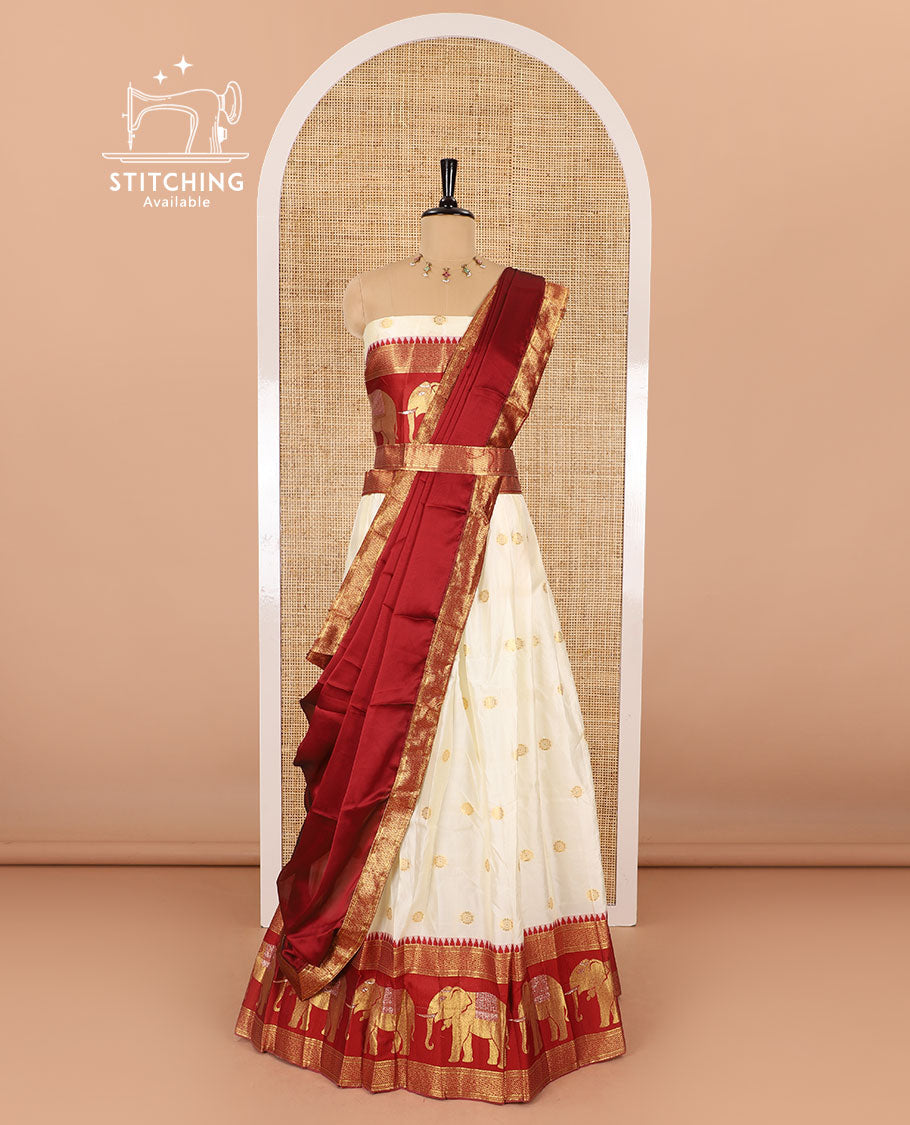 Cream-crimson half-saree, zari buttas with contrast traditional zari elephant motifs bordered skirt, matching blouse and a contrast zari border dhavani